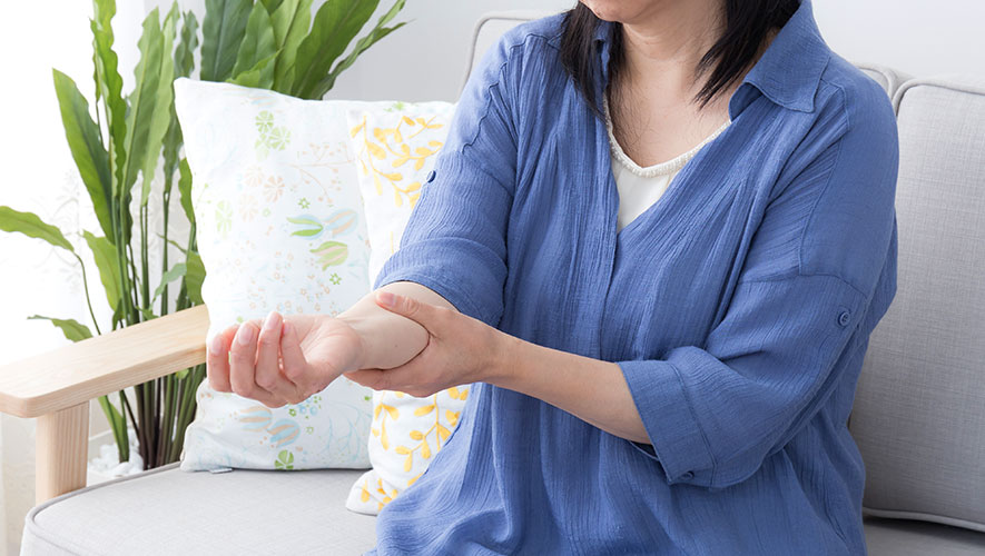 室内で腕をさする女性